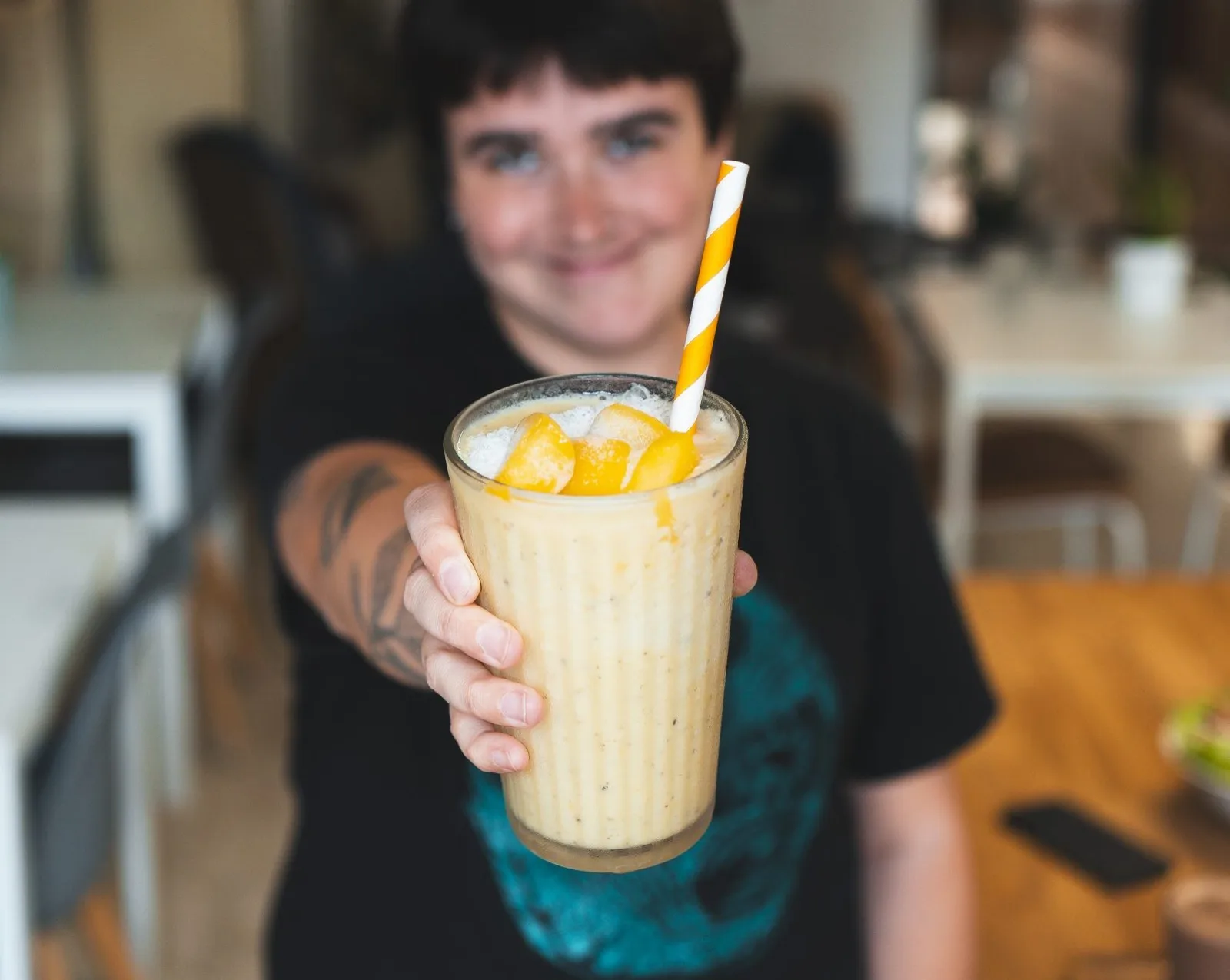 Mango-Smoothie, in die Kamera gehalten